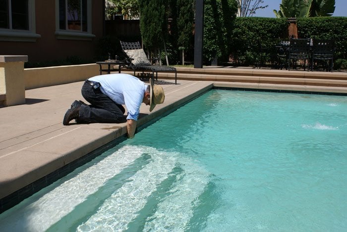 Pool technician checking a clean swimming pool