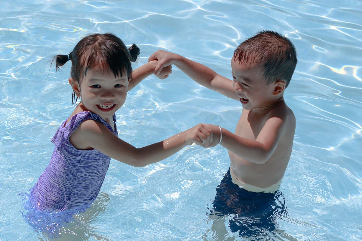 Young kids splashing in a clean swimming pool